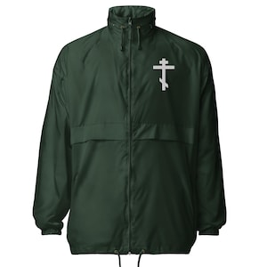 May include: A dark green windbreaker jacket with a white Eastern Orthodox cross emblem on the chest. The jacket has a full zipper, a stand-up collar, and a drawstring at the hem. It is a lightweight, casual outerwear garment.