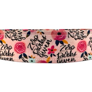 May include: Pink fabric with a floral pattern and the text "Zero Barks Given" repeated.