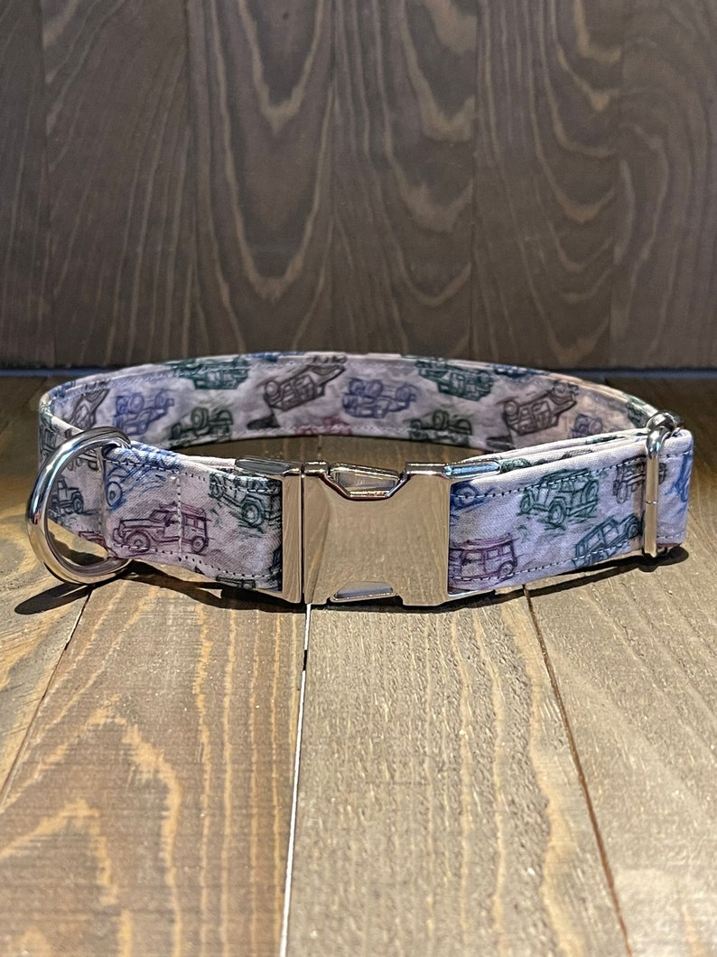 May include: A white dog collar with a silver buckle. The collar has a pattern of vintage cars in shades of blue, green, and gray.