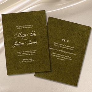 Op de afbeelding: Twee olijfgroene huwelijksuitnodigingen met witte tekst. Op de uitnodiging aan de voorkant staat "Maya Idris en Julian Amari" met evenementdetails. Op de achterkant staat "RSVP" met een website en aanvullende informatie.
