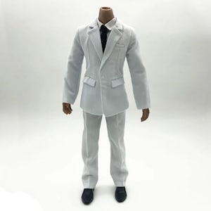 May include: A light grey suit with a black tie and black shoes. The suit includes a jacket with two front pockets and matching trousers. The suit is designed for a doll or action figure.