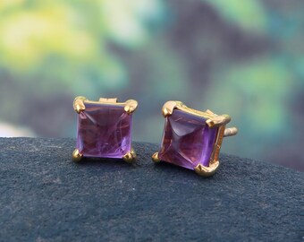 May include: A pair of gold stud earrings with square-shaped amethyst gemstones.