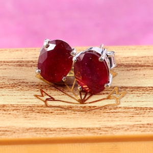 以下が含まれることがあります： 楕円形の赤いルビーの宝石が付いたシルバーのスタッドピアスのペア