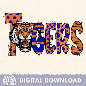 May include: A digital design featuring the word "TIGERS" in orange, blue, and white. The letter "T" has orange polka dots with blue dots, and the letter "G" has blue and orange stripes. A tiger graphic is incorporated into the design.