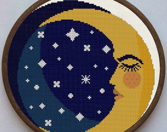 Op de afbeelding: Een gele halve maan met een slapend gezicht en wimpers, omringd door witte sterren op een donkerblauwe achtergrond. De maan is geborduurd op een rond canvas met een houten frame.