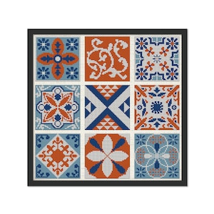 May include: A framed cross-stitch design featuring nine colourful squares with geometric patterns in shades of blue, orange, and white.
