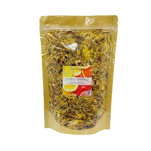 May include: A clear, resealable kraft paper pouch filled with dried potpourri consisting of yellow, orange, and blue botanical flowers and herbs. A central label reads CITRUS SPARKLE, Pot Pourri Made With Botanical Flowers & Herbs.