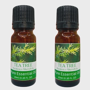 May include: Two amber glass bottles of tea tree essential oil. Each bottle has a black cap and a label with the text "TEA TREE Melaleuca Alternifolia Pure Essential Oil 10ml (0.35 FL OZ)" and a green and white design.