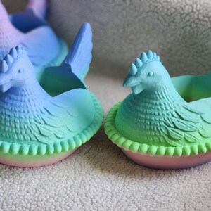 Puede incluir: Varios maceteros de cer&aacute;mica con forma de gallina en tonos azules, verdes y rosas. Las gallinas tienen dise&ntilde;os detallados de plumas y crestas, sentadas en una base en forma de nido. Ideales para peque&ntilde;as plantas.