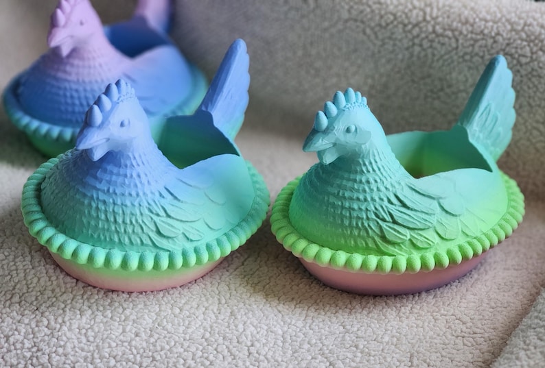 Puede incluir: Varios maceteros de cer&aacute;mica con forma de gallina en tonos azules, verdes y rosas. Las gallinas tienen dise&ntilde;os detallados de plumas y crestas, sentadas en una base en forma de nido. Ideales para peque&ntilde;as plantas.