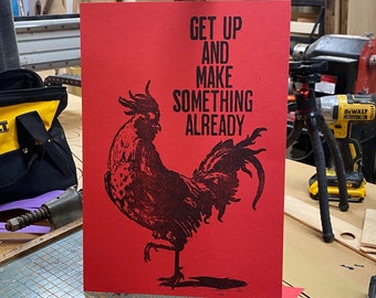May include: Red poster with a black rooster illustration and the text "Get up and make something already".