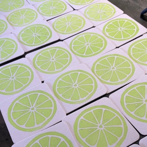 May include: A set of 20 white coasters with a lime green lime slice design. The coasters are made of a thick, absorbent material and are perfect for protecting your furniture from spills and scratches.