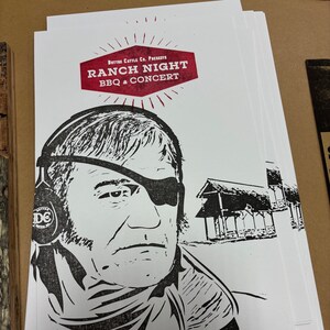 May include: A black and white illustration of a man with an eyepatch and a red banner with the text "Button Cattle Co. Presents Ranch Night BBQ & Concert".