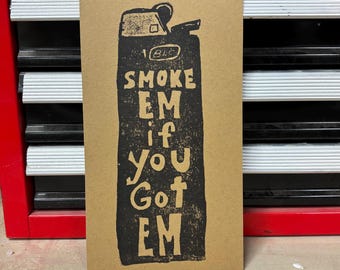 May include: A brown card with a black and white illustration of a lighter with the text "SMOKE EM if you GOT EM".