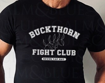Puede incluir: Camiseta negra con un diseño gráfico blanco que dice "Buckthorn Fight Club" con una pequeña imagen de una rama con bayas. El texto "Never Tap Out" está debajo del texto principal.