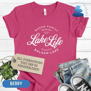 K&ouml;nnte beinhalten: Pinkes T-Shirt mit wei&szlig;em Text, der "Mason Family Reunion Summer 2023 Lake Life Minnesota Balsam Lake" lautet. Der Text ist von einem Kreis umgeben. Ein Etikett unter dem Text lautet "Der gesamte umgebende Text kann personalisiert werden!"