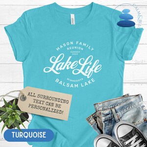 K&ouml;nnte beinhalten: T&uuml;rkisblaues T-Shirt mit wei&szlig;em Text, der "Mason Family Reunion Summer 2023 Lake Life Minnesota Balsam Lake" lautet. Der Text ist von einem Kreis umgeben. Ein Etikett unter dem Shirt lautet "Der gesamte umgebende Text kann personalisiert werden!"