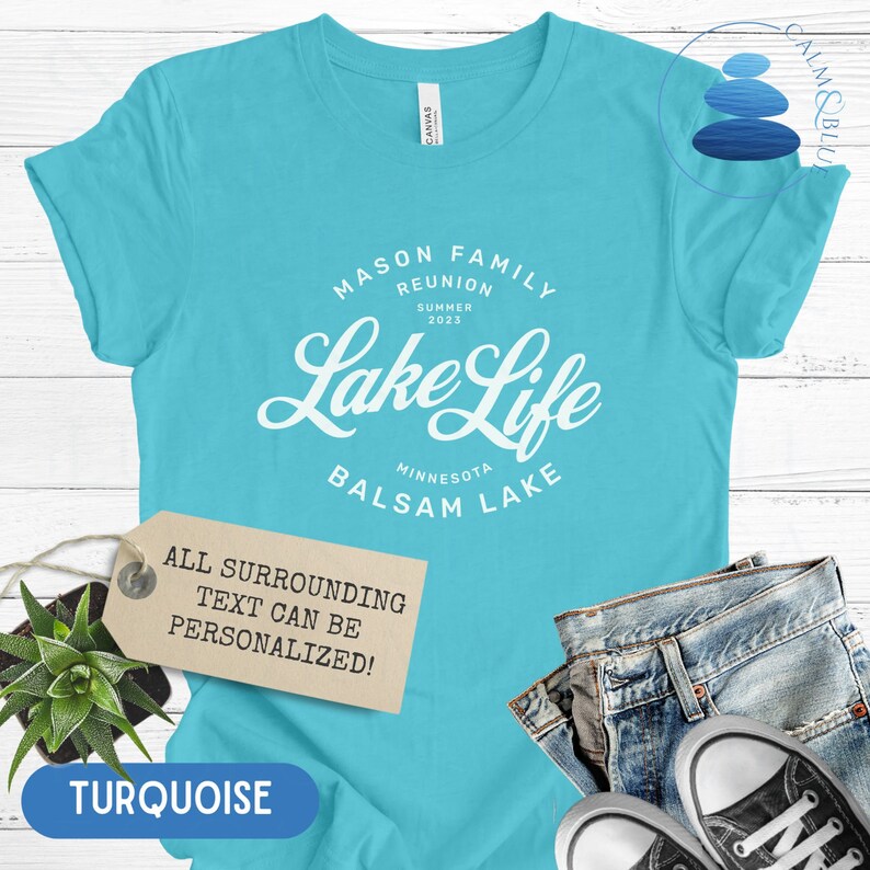 K&ouml;nnte beinhalten: T&uuml;rkisblaues T-Shirt mit wei&szlig;em Text, der "Mason Family Reunion Summer 2023 Lake Life Minnesota Balsam Lake" lautet. Der Text ist von einem Kreis umgeben. Ein Etikett unter dem Shirt lautet "Der gesamte umgebende Text kann personalisiert werden!"