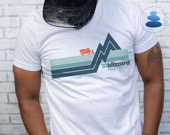 May include: White t-shirt with a blue and green mountain graphic and the text '91 blizzard survivor'.