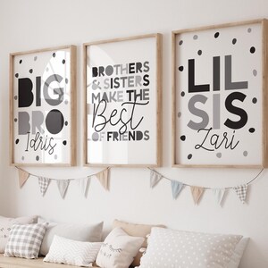 Puede incluir: Tres impresiones enmarcadas con texto negro y gris sobre fondo blanco. Las impresiones están colgadas en una pared blanca sobre un estante de madera con contenedores de almacenamiento. El texto en las impresiones dice "Big Bro Idris", "Brothers & Sisters Make the Best of Friends", y "Lil Sis Lani".
