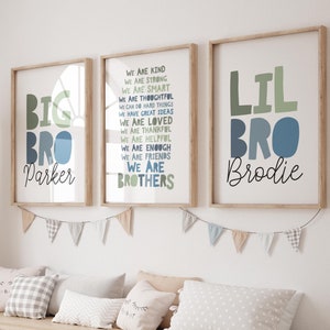 Puede incluir: Dos impresiones enmarcadas con las palabras "Big Bro Parker" y "Lil Bro Brodie" en letras de bloque de colores. La impresión del medio tiene una lista de atributos positivos, que incluyen "amable", "fuerte", "inteligente" y "considerado".
