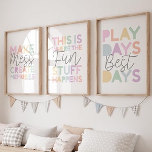 May include: Three framed prints with colorful text on a white wall. The prints say "Make Mess Create Memories", "This is Where the Fun Stuff Happens", and "Play Days Best Days".