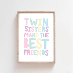 Puede incluir: Una impresión enmarcada con el texto "Twin Sisters Make The Best Friends" en letras de colores. Las letras son en tonos de rosa, amarillo, azul y verde.