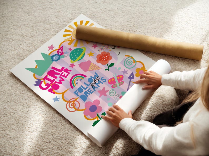 May include: A vibrant poster with the text "GIRL POWER" and "FOLLOW YOUR DREAMS" is decorated with a sun, rainbow, flowers, and other playful illustrations. A rolled-up poster and a brown cardboard tube are also present.