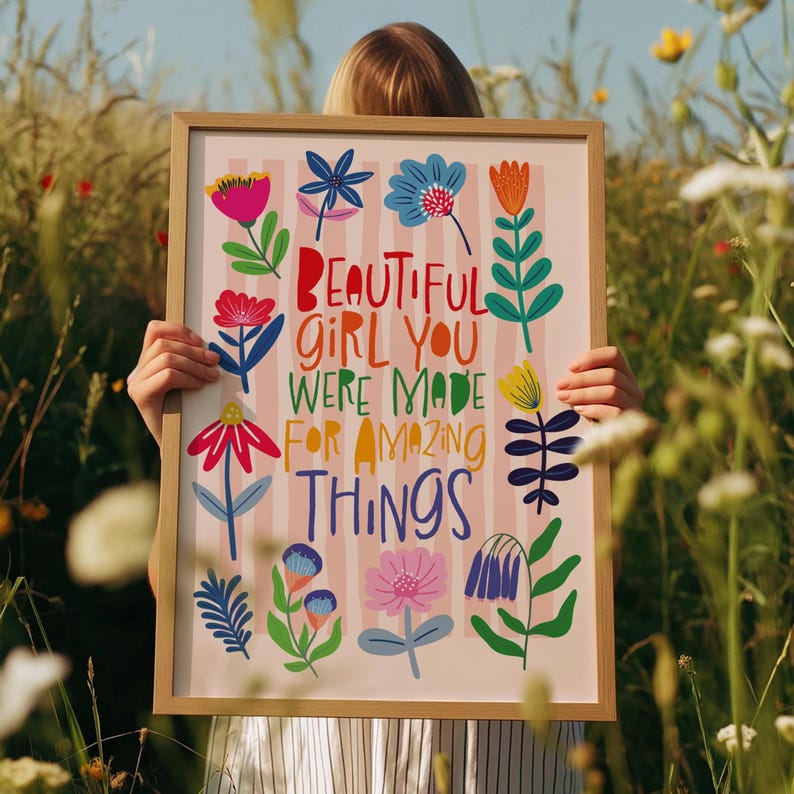 May include: A framed art print with the words "BEAUTIFUL GIRL YOU WERE MADE FOR AMAZING THINGS" in colorful letters. The print features various colorful floral illustrations on a pink and white striped background.