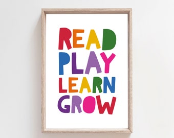 May include: A framed print featuring the words "READ PLAY LEARN GROW" in bold, colourful letters. The words are stacked vertically, each in a different colour.