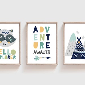 May include: Three framed prints with a woodland theme. The first print features a cartoon raccoon with the text "Hello Explorer". The second print features the text "Adventure Awaits" with an arrow. The third print features a blue teepee with mountains and stars.