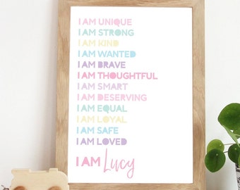 Può includere: Una stampa incorniciata con sfondo bianco e testo colorato che recita "I AM UNIQUE, I AM STRONG, I AM KIND, I AM WANTED, I AM BRAVE, I AM THOUGHTFUL, I AM SMART, I AM DESERVING, I AM EQUAL, I AM LOYAL, I AM SAFE, I AM LOVED, I AM Lucy".