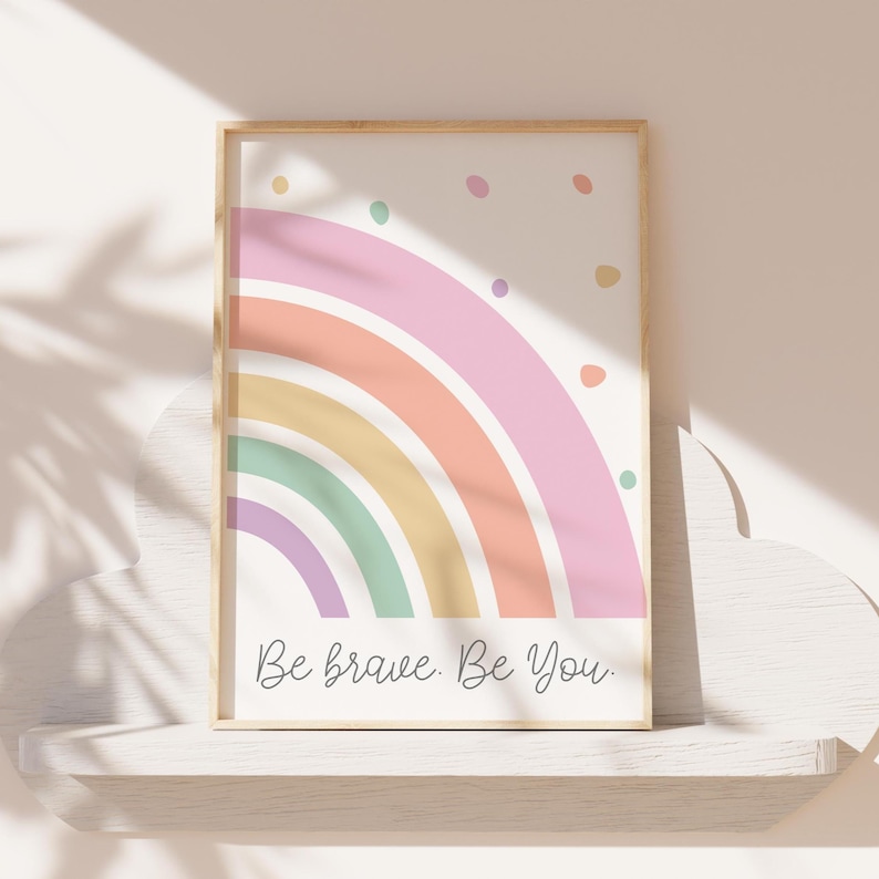 May include: A framed print with a pastel rainbow design and the text "Be brave. Be you." in a white frame.