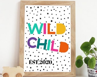 May include: A framed print with a white background and black polka dots. The words "WILD CHILD" are written in colorful letters, with "EST. 2020" below.