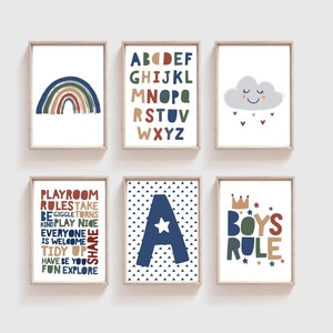 May include: Set of six framed prints with a nursery theme. The prints feature a rainbow, alphabet, cloud, letter A, and the words "Playroom Rules" and "Boys Rule". The prints are in a blue, green, red, and yellow colour scheme.
