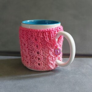 Hand Knitted Cable Mug Cosy/ Cup Warmer in Bright Pink Coloured Yarn with Flowery Button