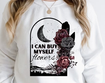 May include: White sweatshirt with a black graphic design featuring a crescent moon, stars, and a bouquet of burgundy and gray roses. The text "I can buy myself flowers" is printed on the graphic.