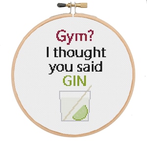 Könnte beinhalten: Gestickte Hoop-Kunst mit dem Text "Gym? I thought you said GIN" in schwarzer und burgunderfarbener Schrift. Unter dem Text befindet sich eine grün-weiße Illustration eines Gin-Glases mit einem Limettenstück und einem Strohhalm.