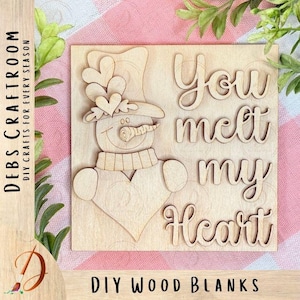 May include: A wooden DIY craft blank featuring a snowman design with a carrot nose, heart-shaped accents, and the words "You melt my Heart." The square wooden piece also has the text "DIY WOOD BLANKS" and "DEBS CRAFTROOM DIY CRAFTS FOR EVERY SEASON."
