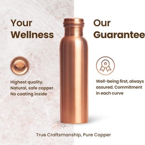 May include: A copper water bottle with a shiny finish. The bottle is on a marble background with text that reads "Your Wellness" and "Our Guarantee".