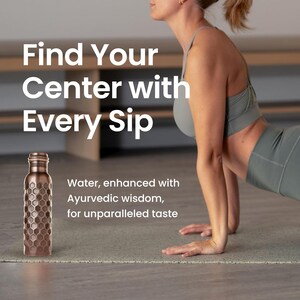 May include: A copper-colored water bottle with a honeycomb pattern sits on a yoga mat. The text reads "Find Your Center with Every Sip." The bottle is next to a person in athletic wear.