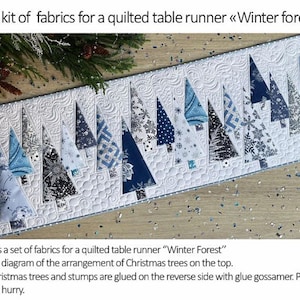 May include: A fabric kit for a quilted table runner titled Winter Forest, featuring a white background with quilted swirl patterns and various blue, navy, and white patterned fabric Christmas tree shapes arranged in a row across the top.