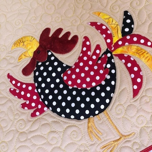 May include: A quilted fabric wall hanging featuring a central rooster appliqué. The rooster has a black body with white polka dots, red wings with white dots, and yellow and black tail feathers. The background is tan with gold swirl stitching.