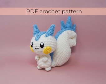 May include: Crochet pattern for a white and blue amigurumi squirrel. The squirrel has a long, bushy tail and a cute, smiling face. The pattern is available as a PDF download.