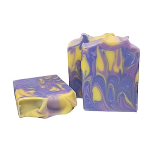 May include: Three bars of handmade soap with a swirl pattern of yellow and purple.