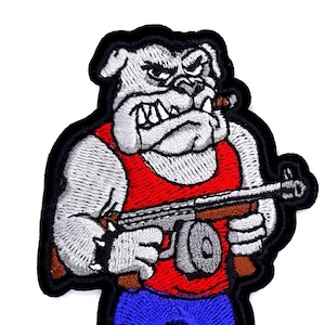 May include: Embroidered patch of a cartoon bulldog wearing a red tank top, blue jeans, and holding a gun. The bulldog has a cigar in its mouth and a menacing expression.