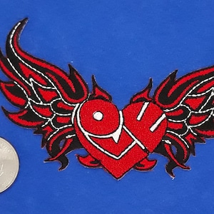 May include: Red embroidered patch with a heart shape with the word "LOVE" inside and black and red wings on either side.