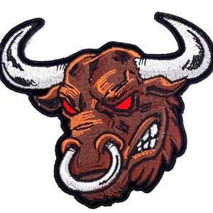 May include: Embroidered patch of a brown bull's head with white horns and a white ring around its nose. The bull has red eyes and a fierce expression.