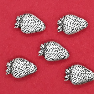 May include: Five silver-toned strawberry-shaped buttons with a textured surface.