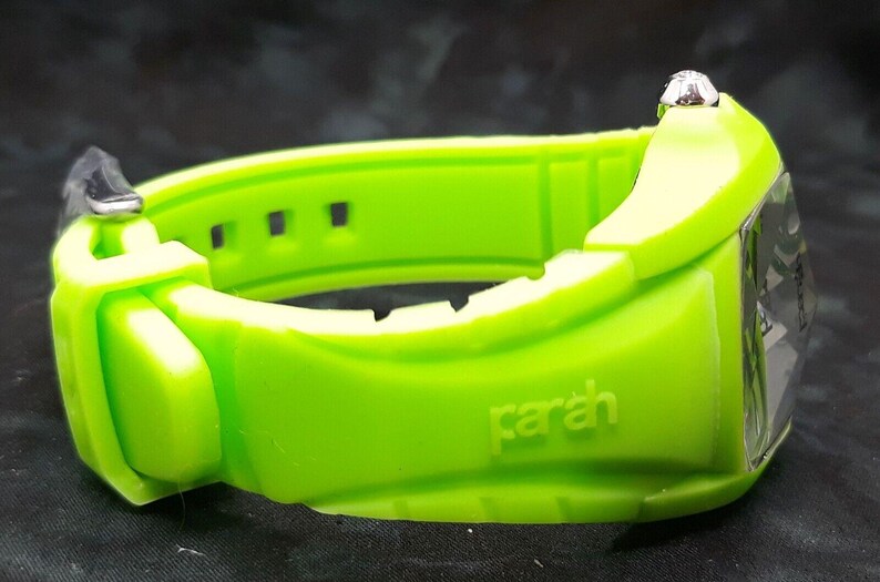 May include: A bright green wristwatch with a silver face and a silicone band. The band has the word "parah" embossed on it.
